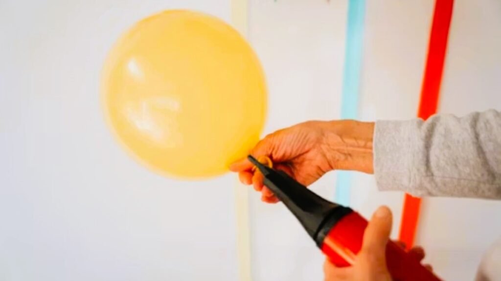 Essential tools for DIY balloon decorations including pump and glue dots