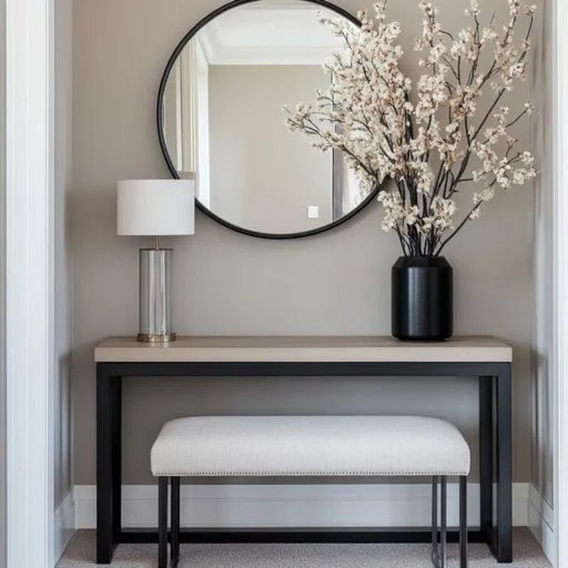 Large round mirror above hallway furniture
